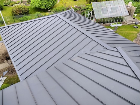 Klassikprofiil plekkkatus eramajal aia taustal