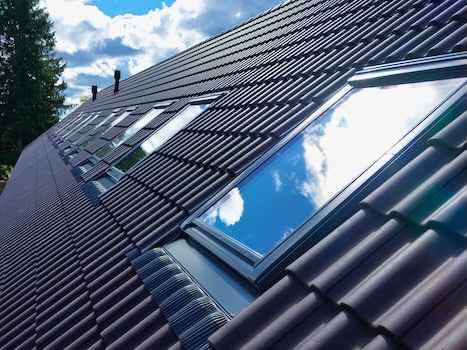 Benders Palema veinipunane kivikatus Velux klapp-svingavanevate katuseakendega eramajal