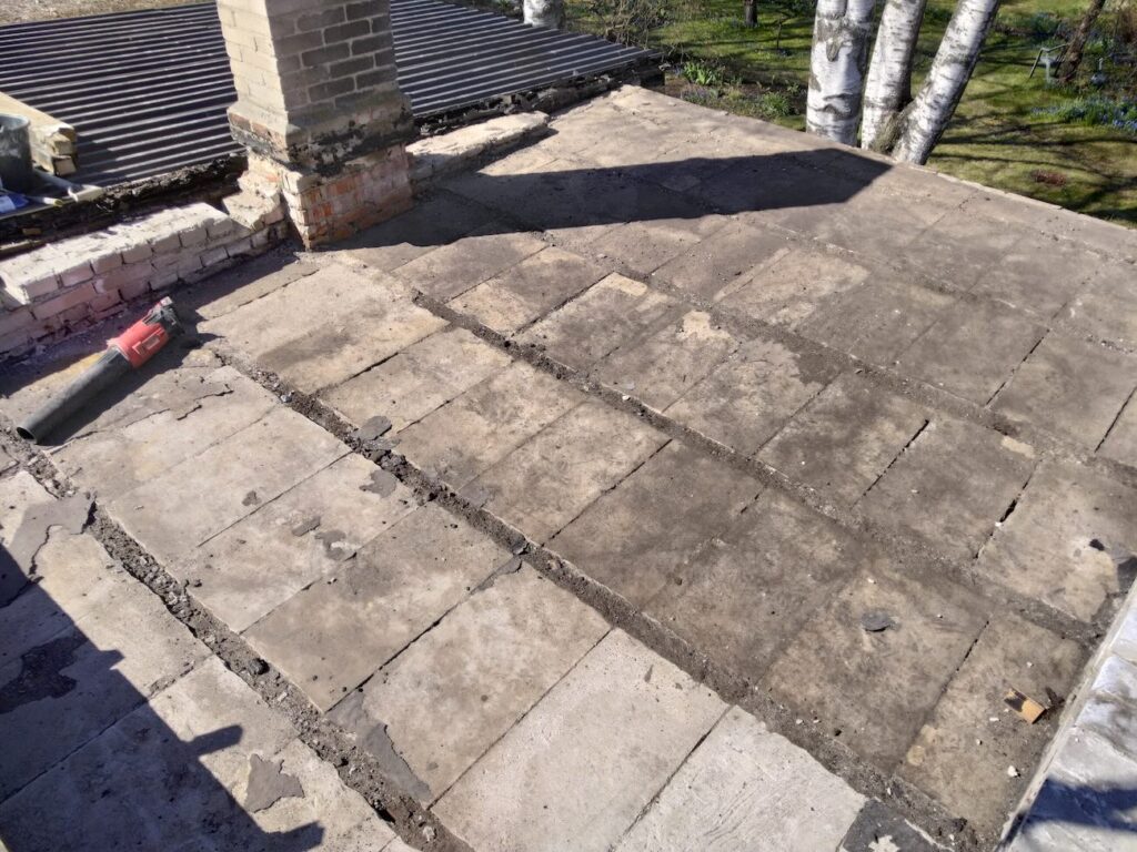 Katuse vana kate eemaldati, avades betoonist aluspaneelid. Ettevalmistus uue aluskile ja roovituse paigalduseks. Katuse uuendus Tallinna elumajal.